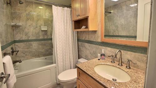 a bathroom with a sink and a toilet and a tub at B307 Moon Bay in Villa Verde