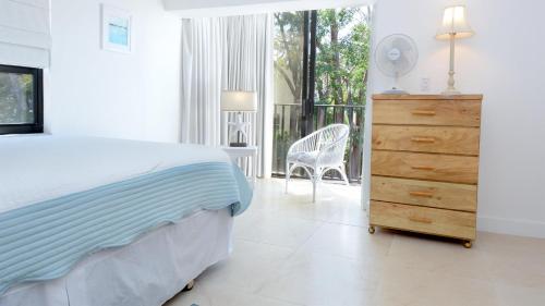 a bedroom with a bed and a dresser and a chair at C14 Moon Bay in Key Largo
