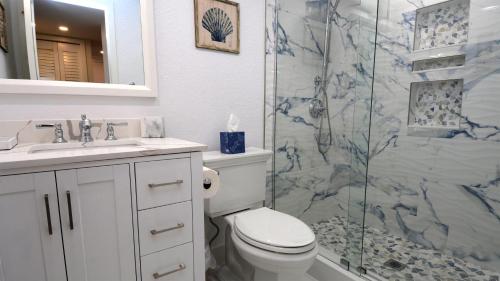 a bathroom with a toilet and a glass shower at A409 Moon Bay in Key Largo