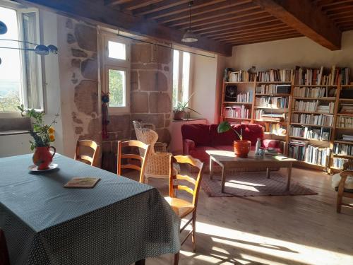 a living room with a table and chairs and bookshelves at Chez Flo in Lamastre