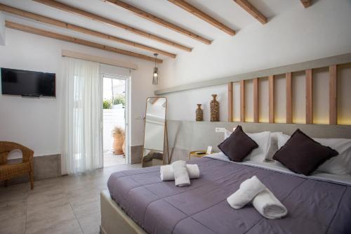 a bedroom with a large bed with towels on it at Alexander Studios & Suites - Adults Only in Faliraki
