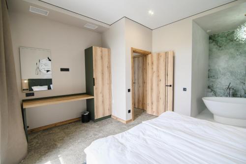 a bedroom with a bed and a tub and a sink at Kryla by Shepilska in Dolgoluka