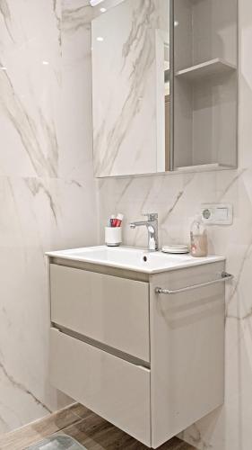 a white bathroom with a sink and a mirror at Lux 2 Central Apartment with Garage in Plovdiv