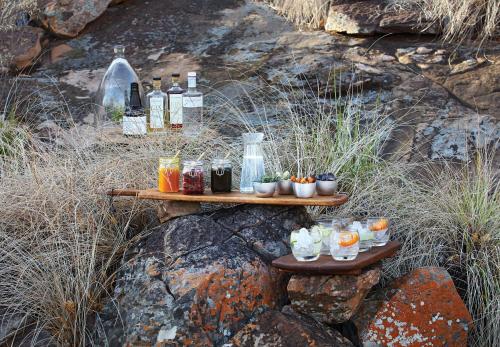 a table with drinks and bottles on a rock at The Outpost in Makuleke Contract Park