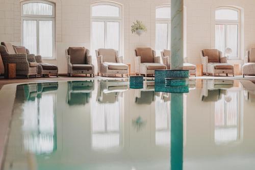 a waiting room with chairs and a pool of water at Tides Boutique Hotel in Norden