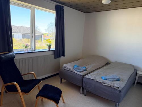 a bedroom with a bed and a chair and a window at Room for rent Solskrænten in Vorgod