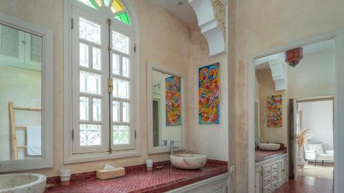 a bathroom with two sinks and two mirrors at Villa NoYa in Oualidia
