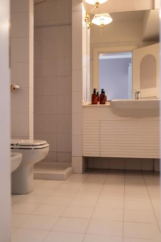 a bathroom with a toilet and a sink at Grand Hotel Molveno in Molveno