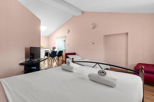 a bedroom with a white bed with towels on it at Villa Kontesa in Lovran