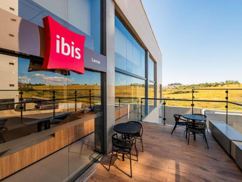 a restaurant with tables and chairs on a balcony at ibis Lavras in Lavras