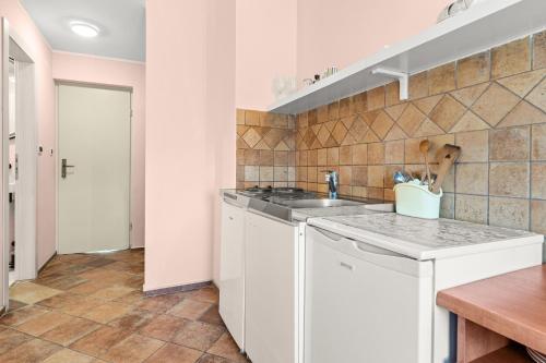 a white kitchen with a sink and a counter at Villa Kontesa in Lovran