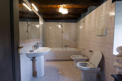 a bathroom with a sink and a toilet and a tub at Dimora Dory Luxury in Nave