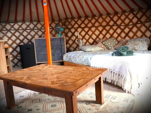 a room with a yurt with a table and a bed at Le Ptit Mas Yourte ou Logicube in Salernes
