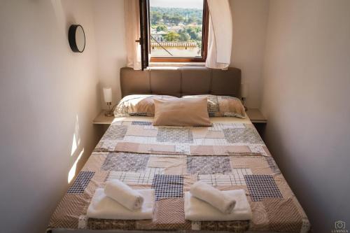 a bedroom with a bed with two pillows and a window at Castello in Mali Lošinj