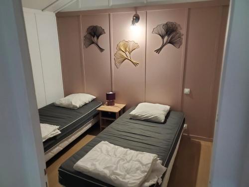 two beds in a room with fish heads on the wall at Chalets du Causse 2 in Gelle