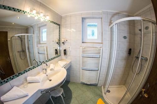 a bathroom with two sinks and a shower at Seehotel Steiner in Seeboden