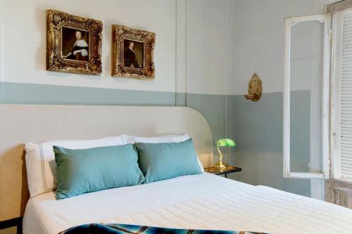 a bedroom with a bed with two pictures on the wall at Artful Hideaway with Pool & Fireplace in Riebeek-Kasteel