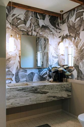 a bathroom with a stone wall with a mirror at Artful Hideaway with Pool & Fireplace in Riebeek-Kasteel