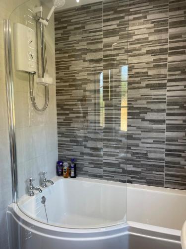 a bathroom with a tub and a glass shower at Ambermay House in Armagh