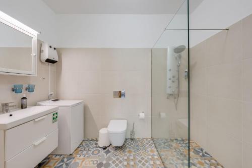 a white bathroom with a toilet and a shower at Studio SeaSky Tabua by Holiday Rental Madeira in Ribeira Brava
