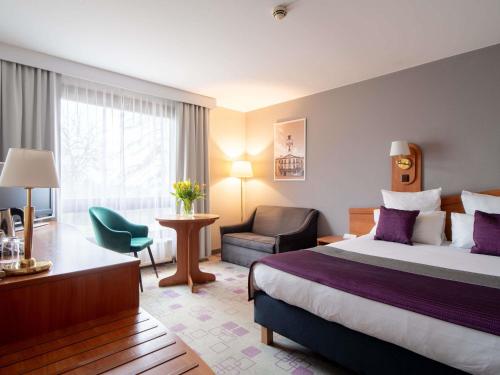 ein Hotelzimmer mit einem Bett und einem Stuhl in der Unterkunft Mercure Cieszyn in Cieszyn