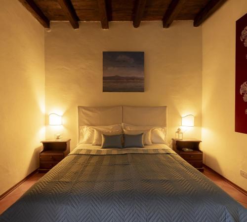 a bedroom with a large bed with two night stands at Le Case di Sottovento in Mola di Bari