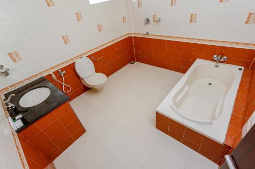 a bathroom with a toilet and a urinal and a sink at Padipura Residency in Alleppey