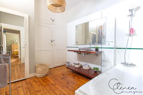 a bathroom with a tub and a sink and a mirror at Evasion in Albi