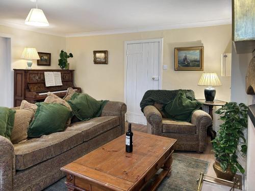 a living room with two couches and a table at Foumartdean Cottage in Town Yetholm