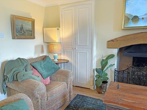 a living room with a couch and a fireplace at Foumartdean Cottage in Town Yetholm