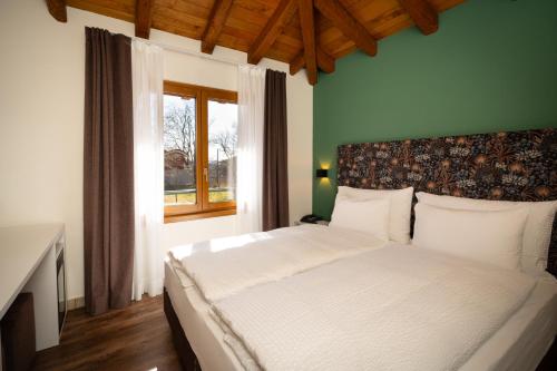 a bedroom with a large white bed with a window at Hotel Il Castagno in Mugena