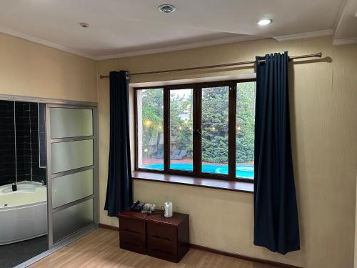 a bathroom with a large window with a tub and a sink at Gatsby Ortosay in Orto-Say