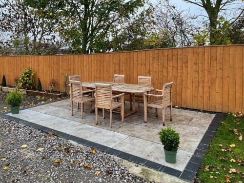 a wooden table and chairs and a fence at Gatherley Loft in Scorton