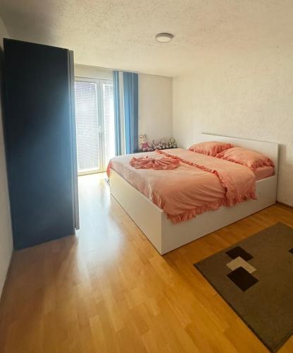 a bedroom with a bed and a large window at Apartman Leki in Sarajevo