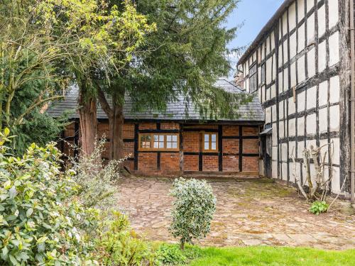 an exterior view of a large building with trees at Gardeners Cottage in Putley