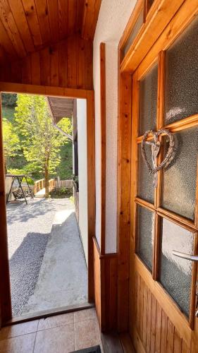 an open door of a wooden house with a window at Chalupa pri potoku in Zuberec
