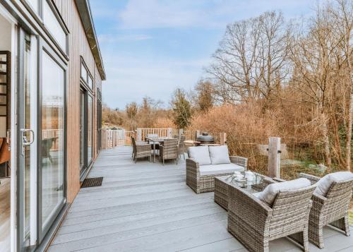 a porch with wicker furniture and a table and chairs at The Astbury Golf And Lodge Resort in Bridgnorth