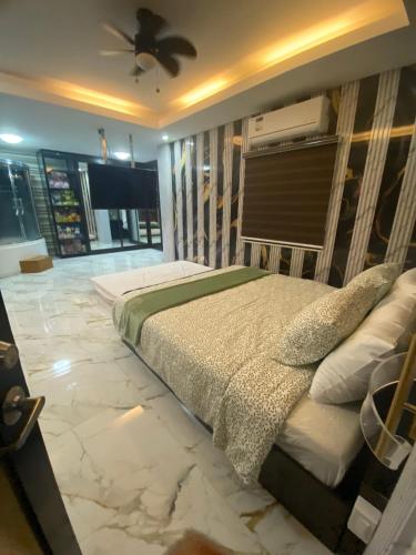 a bedroom with a bed with marble floors and a ceiling at Casa Buenafe in Antipolo