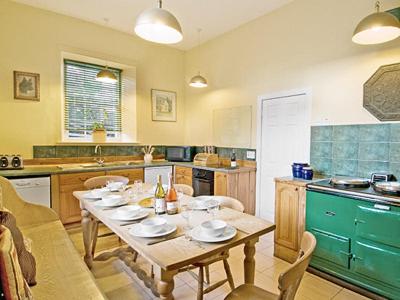 a kitchen with a table with plates on it at Lochside Stable Hse in Town Yetholm