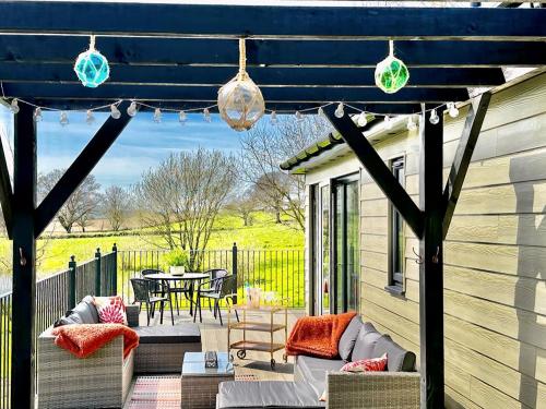 a pergola on a patio with a table and chairs at Talltrees - Uk42842 in Uplowman