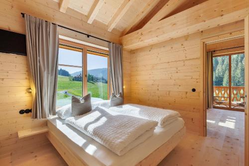 a bed in a wooden room with a window at Archerhof in Racines