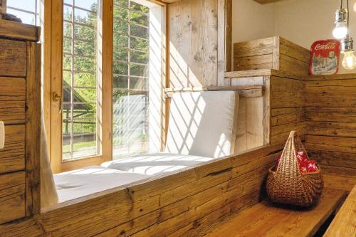 a large window in a room with a bench in front at Baita Dal Bigolaro in Levico Terme