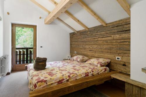 a bedroom with a bed with a wooden headboard at Baita Dal Bigolaro in Levico Terme