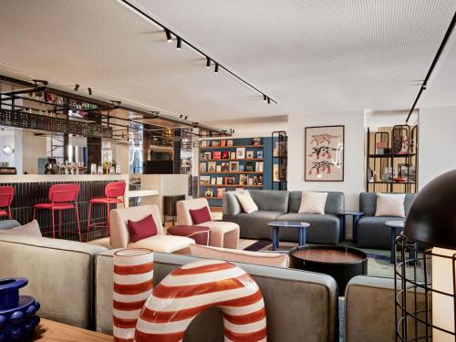 a lobby with couches and chairs and a bar at TRIBE Paris Pantin in Pantin