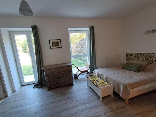 a bedroom with a bed and two large windows at Les Jardins du Bateau in Vals-les-Bains