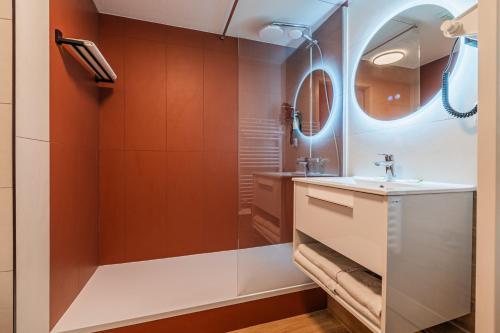 a bathroom with a sink and a shower at Residhotel Mulhouse Centre in Mulhouse