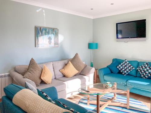 a living room with a couch and a table at Ardstinchar Mews in Ballantrae