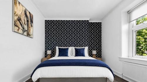 a bedroom with a large bed with blue pillows at Parkview Apartment in Rothesay