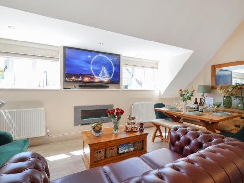 a living room with a couch and a tv on the wall at Kendalls Nook in Shaftesbury