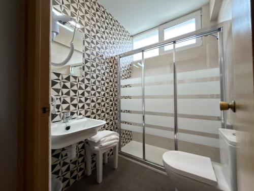 a bathroom with a sink and a toilet at Hostal Restaurante Iruñako in Burgos